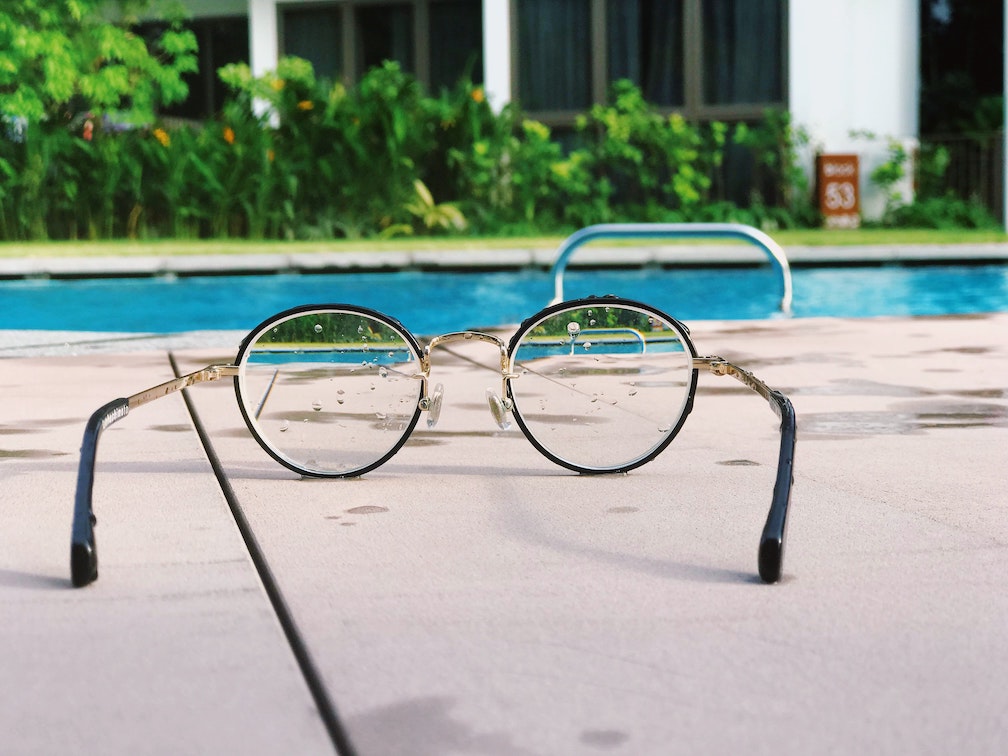 wet reading glasses beside the pool
