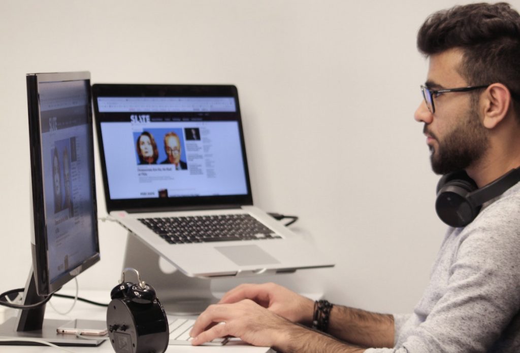man wearing headphones using his computer