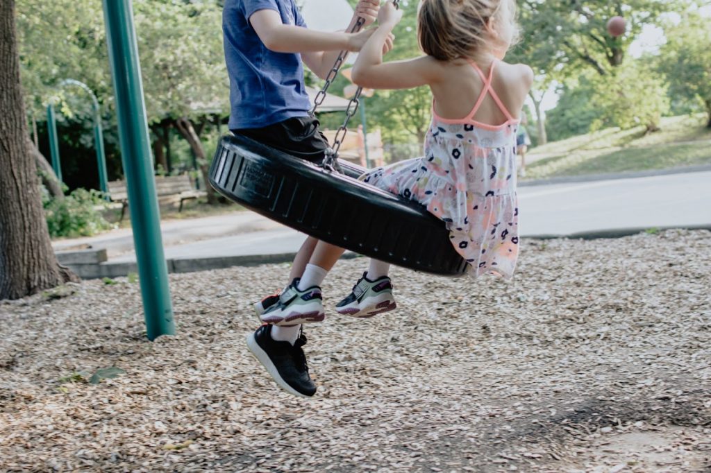 Kids swinging on a tire swing at a playground