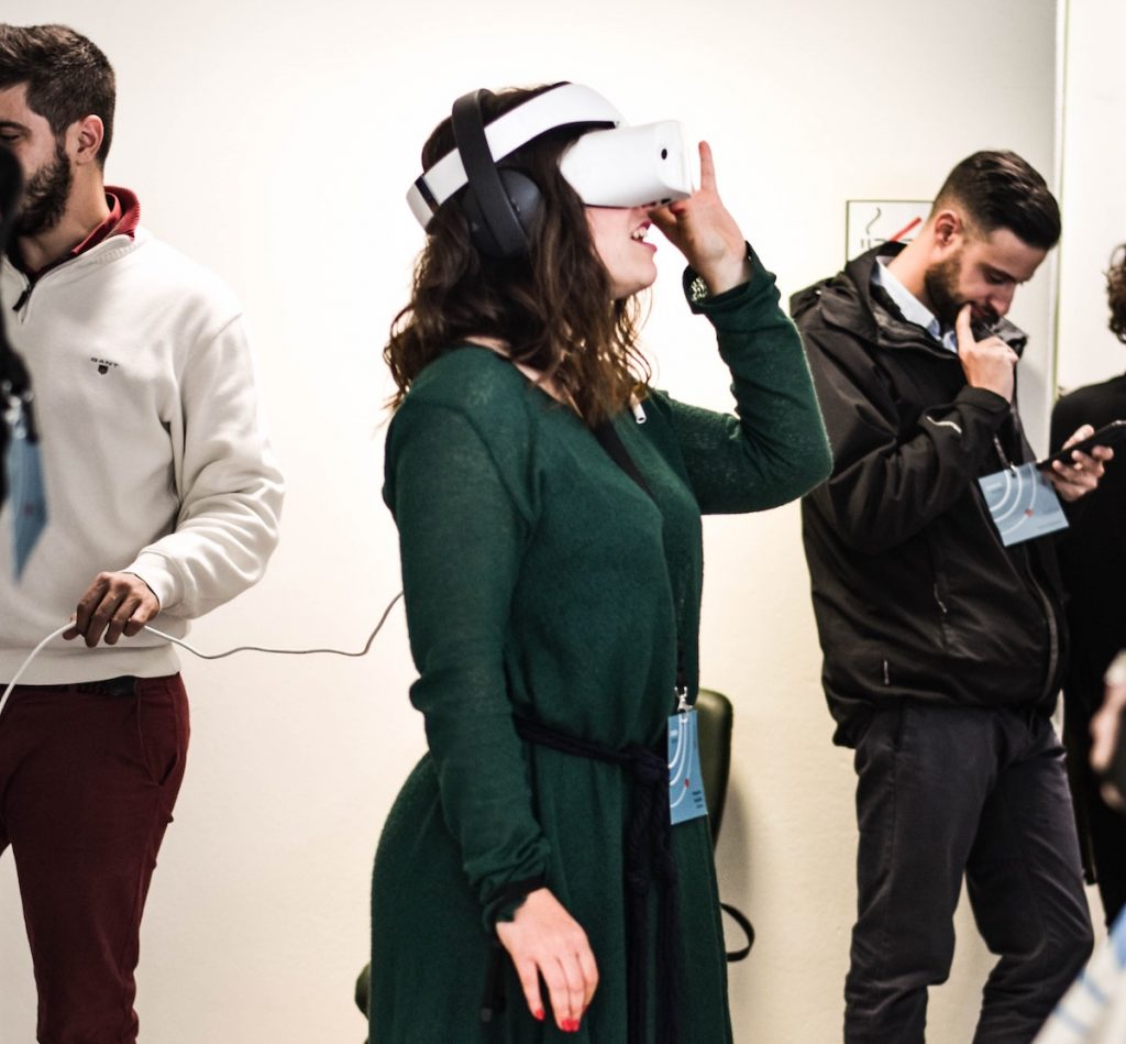 green lady wearing a white VR device
