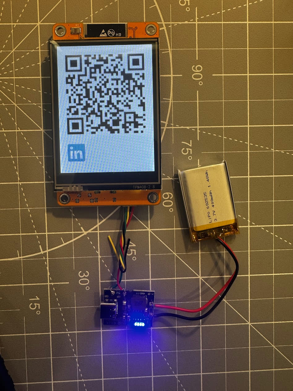 Prototype screen displaying a LinkedIn QR code, wired to the battery and charging module