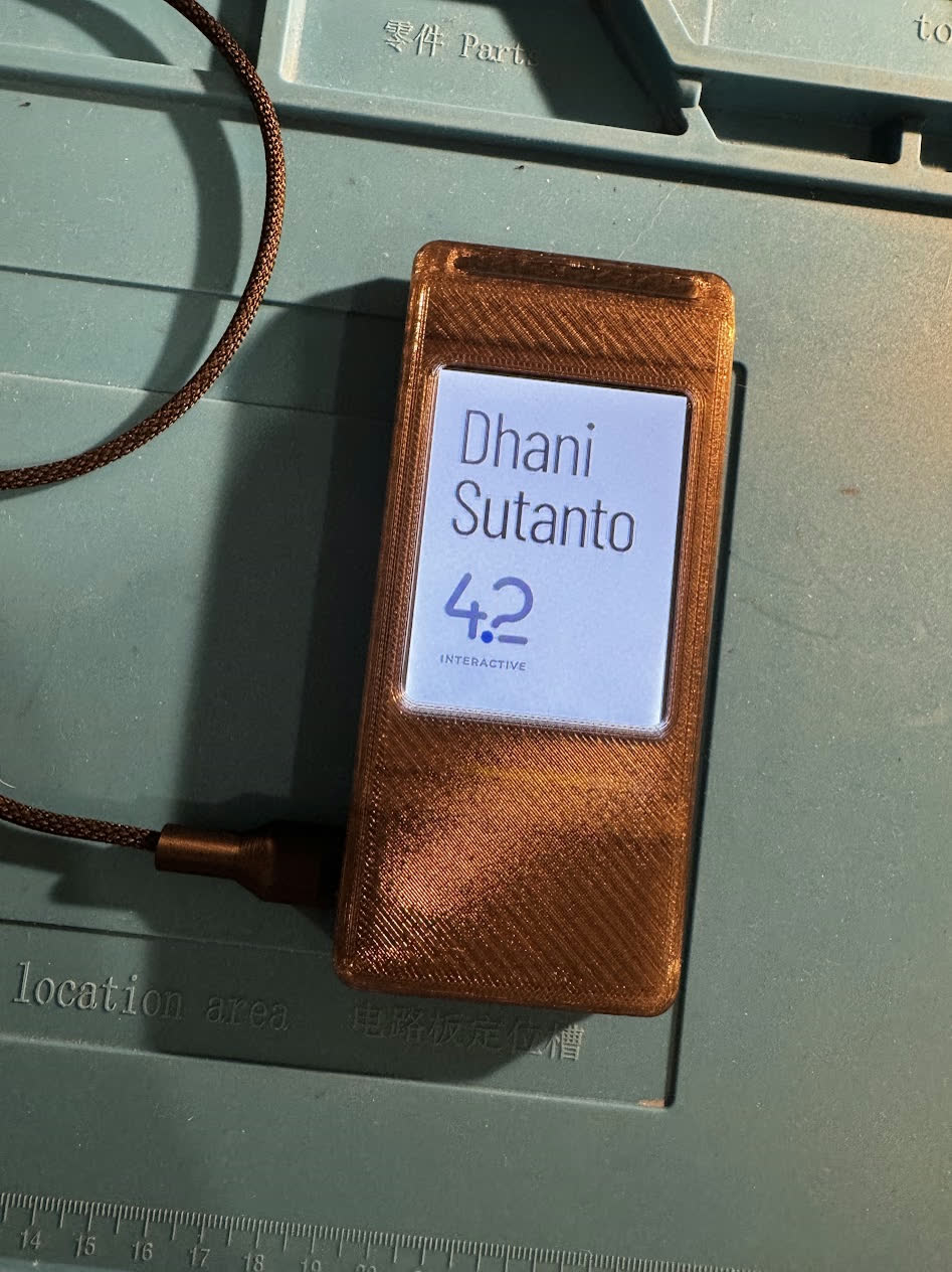 Finished badge in its 3D printed case, plugged into a USB-C cable